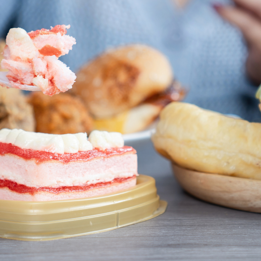 Person eating cake. Lots of different cakes in front of them